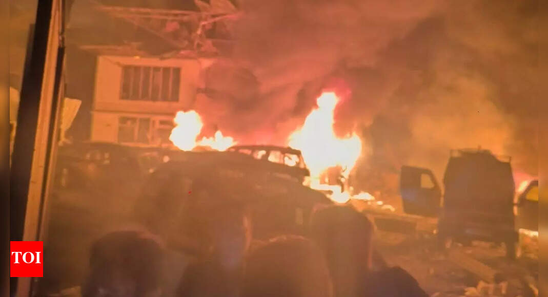 SRINAGAR/NEW DELHI: An “accidental explosion” at Nowgam police station late Friday night, caused by substances seized during raids in an NCR city and transported to Kashmir by police, killed 9 people and injured 30.J&K DGP Nalin Prabhat said at a press briefing in Srinagar on Saturday morning a huge cache of explosive substances, chemicals and reagents were recovered from Faridabad on Nov 9 and 10, during the investigation of an interstate terror module.“The recovery was transported and kept securely in the open area of the police station (Nowgam),” Prabhat said, adding, “As part of prescribed procedure, samples of the recovery had to be forwarded for further forensic and chemical examination. On account of the voluminous and sensitive nature of the recovery, it was being handled with utmost caution. However … an accidental explosion took place at about 11.20 pm on Nov 14. Any other speculation into the cause of this incident is unnecessary.” The DGP didn’t take questions.The Union home ministry, too, said in New Delhi that the Nowgam police station explosion was triggered accidentally as explosives recovered from the recently busted terror module were being handled and sampled by forensic experts and other agencies ahead of their transport to FSL, Jammu.There are SOPs for handling and sampling seized explosives and officials in Delhi said these were followed in Nowgam as police personnel, magisterial staff and forensic experts continued working late into Friday night to complete the sampling. Though protective gear, like bomb suits, is available, forensic teams rarely use them. Officials said an external agent yet to be ascertained but which could be a flying spark from something nearby, may have triggered the explosion, with the cars of teams parked nearby adding to its magnitude.The explosion at the police station, operating from a private house in the heart of Nowgam’s posh Sheikh-ul-Alam Colony, shook large parts of Srinagar and reduced the police station to rubble. Among the nine killed were a Special Investigation Agency officer, three Forensic Science Laboratory personnel, two revenue officials, and a tailor associated with the police station. Thirty others — 27 policemen, two revenue officials and three civilians — were wounded.Nowgam police station had investigated the Jaish-e-Mohammed posters that appeared in Bonpora area of Nowgam on Oct 19, an inquiry that led to the busting of an interstate terror module involving doctors and others.Ruling out any terror angle, J&K DGP Prabhat said the cause of this “unfortunate incident” is being inquired into. L-G Manoj Sinha said govt stands in solidarity with the families, friends, and loved ones of the departed. “All possible assistance is being provided to those affected. I’ve ordered a probe to ascertain the cause of the accidental explosion,” he added.MHA officials told TOI that around 358 kg of explosives recovered from Faridabad was transported in a Tata 407 goods carrier to Nowgam police station earlier this week as “case property”. As per the law case property, comprising recoveries from all raided locations, must be deposited at the police station where the FIR is registered.“Deeply anguished by the loss of precious lives due to extremely tragic accidental blast at Nowgam Police Station in Srinagar. My condolences to the bereaved families. I pray for speedy recovery of the injured,” the L-G said in a post on X. CM Omar Abdullah extended his “heartfelt condolences” to the bereaved families and prayed for the swift recovery of those injured.Later in the day, when some media channels reported that People’s Anti-Fascist Front (PAFF), a JeM proxy declared a “terrorist organisation” by the Union home ministry in 2023, had claimed responsibility for the “attack”, the police issued a quick rebuttal: “The claim of PAFF or any other Pakistani terrorist group is patently false, baseless and mischievous.”J&K police had placed concertina wire at the entrance to Sheikh-ul-Alam Colony on Friday, and policemen carrying AK-47s were allowing people to pass only after thorough checks. The road leading to Nowgam police station, located deep inside the colony, was covered with shattered window panes, twisted tin sheets and other debris as residents stepped out to describe what happened the previous night.“It felt like it was a missile strike,” said a resident living a few hundred metres from the police station. He said he was asleep when a loud bang shook his two-storey house and window panes fell onto his bed. For a moment, he said, he believed a fresh war between India and Pakistan had started. “Then I heard cries, and in the neighbourhood several young girls staying here for studies screamed. It was complete mayhem.”Another resident said he grabbed his child and ran outside after the explosion, seeing policemen fleeing in panic. “One policeman kept saying he was fine, and then blood started coming out of his mouth and he fell down,” he said. Another resident said that when he stepped out and walked towards the police station, he saw a man completely covered in black powder asking for help. “I gave him a cloth to clean himself, and I recognised him as the cook of the police station, who had survived.”Nowgam police station was housed in a rented building for the past three decades. “I have always seen the police station here. I think in 1997 there was a cylinder blast at the station,” a resident said. He said that over the past few days the police station had seen heavy movement, with several officials visiting regularly station as an “important case was being investigated there”.A labourer who works as a chowkidar in a building near the police station said there was a big blast followed by several smaller explosions that shattered windows and cracked walls in the locality. He said that in the morning he saw policemen recovering some body parts. He said the fire service had arrived within 10 minutes of the explosion and helped douse the flames and save the locality.The police station now lies in complete ruin. Its gate and boundary walls are gone. Several vehicles on the road outside are damaged, their window panes blown out. Inside the compound, charred vehicles lie flipped over by the blast, and the building itself is now a heap of rubble.A young man whose house is adjacent to the police station and separated only by a wall said the blast threw him off his feet and falling window glass injured his eyes and face. He then rushed to the nearby Ujala hospital, across the main road. Those killed in the blast were from different parts of the Valley. Relatives and friends were inconsolable at the wreath-laying ceremony at the police control room, Srinagar.When the body of tailor Mohammad Shafi Parry was brought home in Nowgam on Saturday afternoon, mourning erupted across the area. Locals said he was widely loved and an active social worker in the community.Names of the killedShowkat Ahmad Sheikh of Qamarwari Srinagar (Lab Assistant, FSL Srinagar)Mohammad Amin of Bemina Srinagar (head constable, FSL Srinagar)Aijaz Ahmad of HMT Srinagar (constable, FSL Srinagar)Javid Mansoor Rather of Haripari Tral (Crime Photographer)Arshid Ahmad Shah of Chansar Kulgam (Crime Photographer)Inspector Asrar Ahmad of Shahwali Muqam Kupwara (State Investigation Agency)Mohammad Shafi Parray of Nowgam (Tailor)Suhail Ahmad Dar of Wanabal, Srinagar (Revenue)Muzaffar Ahmad of Check Soibug, Budgam (revenue officer)End of ArticleFollow Us On Social MediaVideos’MMC’: PM Modi Mocks Congress After NDA’s Bihar Win; Calls It ‘Muslim League Maoist’ Party‘Abandoned Tribals To Their Fate’: PM Modi Accuses Congress Of Neglecting Tribal CommunitiesCDS General Anil Chauhan Highlights Inter-Service Jointness And Integration In Op SindoorEAM Jaishankar, Russian FM Lavrov To Hold Talks In Moscow On Nov 17 Ahead Of Putin’s India TripAir Marshal AK Bharti Reveals Why India Ended Operation Sindoor After Achieving Its Core ObjectiveWTO DG Okonjo-Iweala Lauds India’s Trade Strategy, Calls For Multilateral LeadershipPakistan Rejects Taliban Narrative And Says Rising Terror From Afghan Soil Can No Longer Be IgnoredNDA Sweeps Bihar, Nitish Kumar Prepares for 10th CM Oath; A Look Back at ‘Sushasan Babu’s’ JourneyPiyush Goyal Says India Ready For WTO Leadership, Rejects Reform Agendas Pushed By Developed NationsJ&K Police Confirm 9 Killed in Nowgam Blast After Explosives Recovered From Faridabad Blows Up123Photostories5 must-have pieces for a winter capsule wardrobeMahesh Babu to Priyanka Chopra: 5 best celebrity looks of the day5 easy exercises for shoulder painreliefSmelling this fragrance can instantly improve focus and supercharge the brain, and no, it’s not coffee6 easy and science-backed snacks that fight colon cancerMold Toxicity: How to recognize its symptoms that appear like a common cold7 phrases parents can say instead of ‘No’ to kidsExclusive – Bigg Boss 19: Mridul Tiwari reacts to his eviction, calls Farrhana Bhatt ‘toxic’ and ‘evil’, and comments on Amaal Mallik’s image being ‘white-washed’Animal protein vs plant protein: Which is best for meeting the body’s nutritional needs?10 phrases parents should never tell a child123Hot PicksAlinagar Election ResultRaghopur Election ResultBihar Election Result 2025Gold rate todaySilver rate todayPublic Holidays NovemberBank Holidays NovemberTop TrendingCarey Price WifeArjun TendulkarTyreek HillsDubai Prince Sheikh Hamdan Net WorthZack RyderPat NarduzziJack DohertyWayne Gretzkys SonDak PrescottPercy Harvin
