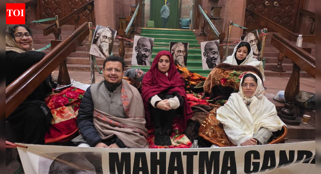 NEW DELHI: Opposition parties staged a 12-hour overnight dharna in the Parliament complex on Thursday night to protest the passage of the Viksit Bharat Guarantee for Rozgar and Ajeevika Mission (Gramin) Bill, or VB-G RAM G Bill, which replaces the Mahatma Gandhi National Rural Employment Guarantee Act.The protest came hours after Parliament cleared the Bill amid noisy scenes and walkouts. The Rajya Sabha passed the legislation post midnight by a voice vote, following its approval by the Lok Sabha earlier in the day, even as opposition members demanded its withdrawal and sought its referral to a parliamentary panel.Lok Sabha Passes Viksit Bharat G Ram G Bill Amid Protests, Opposition Tears Copies Over Gandhi NameOpposition MPs accused the government of rushing the Bill through without adequate debate and of scrapping a flagship rural employment scheme that, they said, supported crores of poor households. Several members walked out of the Upper House, raised slogans against the government and tore copies of the Bill, prompting repeated warnings from the Chair.Trinamool Congress Rajya Sabha deputy leader Sagarika Ghose alleged that the government had “bulldozed” the legislation. “This is an insult to India’s poor, it is an insult to Mahatma Gandhi, it is an insult to Rabindranath Tagore. With just five hours’ notice, this bill was given to us. We were not allowed a proper debate,” she said.“Our demand was such an important bill should be sent to the Select Committee and let the opposition parties examine it, let the opposition parties discuss it, let all stakeholders discuss it, but no, in a display of tyranny, in a murder of democracy,” Ghose said, announcing the overnight protest. “We are now going to sit on a 12-hour dharna, 12-hour dharna against the manner in which the Modi government has brought this black law against the people of India, against the poor of India, against the rural poor of India.”Congress general secretary Randeep Singh Surjewala described the development as a “sad day for the country’s labour force” and alleged that the government had hit the livelihoods of millions. “This is perhaps the saddest day for the labourers of India. BJP government has attacked the livelihood of 12 crore people by repealing the MGNREGA. They have proved that the Modi government is anti-farmer and anti-poor,” he said.Congress leader Mukul Wasnik said the original law was framed after extensive consultations. “When MGNREGA was drafted, consultations were held for 14 months. It was passed by Parliament with consensus. The scheme would put an extreme burden on states. As a result, this scheme will collapse,” he said.DMK leader Tiruchi Siva accused the government of erasing Mahatma Gandhi’s legacy. “Likewise they have removed Mahatma Gandhi’s name himself. Without Gandhi there is no freedom, that is the total belief in this country. Even in Britain parliament we are having Gandhi statue, but here in Indian parliament his statue is hidden somewhere, and now the scheme which bore his name, his name has also been removed,” he said.Defending the legislation, Rural Development Minister Shivraj Singh Chouhan said the new law was necessary to address shortcomings in the old scheme and to boost rural development. “This Bill is very necessary as it will help provide employment opportunities, help development of rural India and take the country forward,” he said while replying to the debate in the Rajya Sabha.Chouhan accused the Congress of misusing Mahatma Gandhi’s name for political gains and of disrupting parliamentary proceedings. “I heard the opposition with patience all these hours and expected the opposition to hear my response to the discussion. Making their points, making allegations and running away is like murdering the dreams and ideals of Mahatma Gandhi,” he said.“The entire nation is watching their ‘goondagardi’ and the opposition is committing the sin of insulting democracy. House ‘dadagiri se nahin chalega’,” the minister added.He also cited funding figures to defend the government’s record, claiming that while the previous UPA government released Rs 2.13 lakh crore for MGNREGA, the NDA had released nearly Rs 8.53 lakh crore. The opposition, however, maintained that the passage of the Bill without detailed scrutiny set a dangerous precedent and said it would take its protest against the law to the streets across the country.About the AuthorTOI News DeskThe TOI News Desk comprises a dedicated and tireless team of journalists who operate around the clock to deliver the most current and comprehensive news and updates to the readers of The Times of India worldwide. With an unwavering commitment to excellence in journalism, our team is at the forefront of gathering, verifying, and presenting breaking news, in-depth analysis, and insightful reports on a wide range of topics. The TOI News Desk is your trusted source for staying informed and connected to the ever-evolving global landscape, ensuring that our readers are equipped with the latest developments that matter most.”Read MoreEnd of ArticleFollow Us On Social MediaVideos’Abrupt Variation In Chenab River Flow’: Pakistan Cries Over Indus Water Treaty Suspension’Asking Since June…’: Priyanka Gandhi, Nitin Gadkari Share ‘Appointment’ Banter In Lok Sabha’Possibilities For Expansion’: Argentinian Envoy On Trade Partnership With IndiaCM Mamata Banerjee Renames West Bengal’s Job Guarantee Scheme ‘Karmashree’ After Mahatma GandhiNitish Kumar’s Hijab Shocker: BJP MP Giriraj Singh Defends Bihar CM’s Act With ‘Go To Hell’ RemarkIndia Flags Pakistan Role In Bangladesh Protests, Backs Awami League Demand For Free & Fair PollsIndia’s Silent Exodus: Over Two Lakh Indian Citizens Quit Passports Yearly Amid Changing AspirationsApache AH-64e And Prachand Give India A Two-Front Air Strike Edge From Deserts To High HimalayasLok Sabha Passes Viksit Bharat G Ram G Bill Amid Protests, Opposition Tears Copies Over Gandhi Name‘Worst Is Behind Us’: IndiGo CEO Says Airline Back on Track After Operational Crisis123PhotostoriesHow to grow peppers indoors for year-round fresh harvestsShah Rukh Khan’s ‘King’, Ranbir Kapoor’s ‘Ramayana’, Alia Bhatt’s ‘Alpha’, Deepika Padukone in Atlee’s film with Allu Arjun: Bollywood A-listers all set to make a splash in 2026Binging on midnight snacks? Late-night eating can damage your digestive system and affect heart and metabolic disease riskYubari King Melon: Japan’s most luxurious fruit costs ₹27,000 a piece; here’s why it’s so expensiveBreaking the link between smoking and lung cancer: Support for prevention and pain reliefKareena Kapoor Khan proves red is the only colour you need this ChristmasTop 8 dry fruits to boost immunity during the cold winter monthsJyotika’s unforgettable Bollywood moments from Doli Saja Ke Rakhna to ShaitaanDry mouth that won’t go away? Doctor explains if it is dehydration or something elseWinter’s hidden heart hazard: Why cold snaps spike attacks123Hot PicksTrump Gold CardUAE WeatherIndia Oman TradeGold rate todaySilver rate todayPublic Holidays DecemberBank Holidays DecemberTop TrendingTravis Kelce Retirement RumorsAnthony Richardson InjuryJaylen BrownWNBASan Francisco GiantsCam SkatteboPuka NacuaJake PaulSidney CrosbyMike Liaory