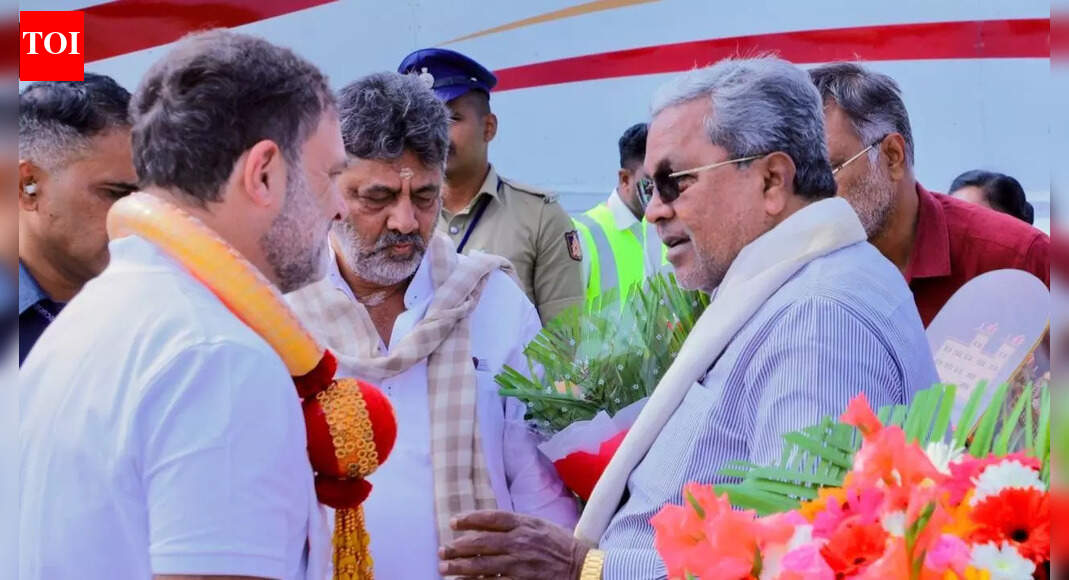 Rahul Gandhi, DK Shivakumar and Siddaramaiah NEW DELHI: Congress leader Rahul Gandhi briefly met Karnataka chief minister Siddaramaiah and deputy CM DK Shivakumar at the Mysuru airport on Tuesday, fuelling speculation amid the ongoing power tussle between the two state Congress stalwarts. The interaction took place on the tarmac during Gandhi’s transit halt while returning to Delhi from Tamil Nadu. He spoke to both leaders, separately and together. Gandhi transited through Mysuru twice during the day—while travelling to Tamil Nadu and again on his return—with Siddaramaiah and Shivakumar present on both occasions.While the contents of the discussion are not known, party sources said it centred on the Congress’ “Save MGNREGA” campaign and the Karnataka government’s contribution to push for restoration of the 2006 legislation implemented by the erstwhile Congress-led Union government. The meeting came as both leaders were seeking an appointment with Gandhi.Siddaramaiah is reportedly pressing for a Cabinet reshuffle, while Shivakumar wants clarity on a leadership change. Party insiders believe approval for a reshuffle would indicate Siddaramaiah is set to complete his full term, weakening the prospects of Shivakumar, who also heads the party’s state unit.Speculation over a potential leadership change has intensified since the Congress government crossed the halfway mark of its term in November last year, amid reports of an unconfirmed power-sharing arrangement at the time of government formation in May 2023. Siddaramaiah later told reporters there was “no confusion” within the party and said no political discussions took place during his meeting with Gandhi.(With PTI inputs)About the AuthorTOI News DeskThe TOI News Desk comprises a dedicated and tireless team of journalists who operate around the clock to deliver the most current and comprehensive news and updates to the readers of The Times of India worldwide. With an unwavering commitment to excellence in journalism, our team is at the forefront of gathering, verifying, and presenting breaking news, in-depth analysis, and insightful reports on a wide range of topics. The TOI News Desk is your trusted source for staying informed and connected to the ever-evolving global landscape, ensuring that our readers are equipped with the latest developments that matter most.”Read MoreEnd of ArticleFollow Us On Social MediaVideosCentre Steps In To Scrap 10 Minute Delivery Timers After Safety Fears In India’s Gig Economy GrowMarvel Meets Maharashtra Politics, AI Reels On Civic Polls Turn Thanos, Hulk, Spider-Man Into NetasUS Threatens 25% Tariff on India-Iran Trade, Indian Rice Exporters Warn of LossesIndia To Face 75% US Tariffs After Trump’s Big Iran Announcement?Operation Sindoor Turning Points Revealed: Army Chief Tells What Forced Pakistan To Seek CeasefirePakistan’s Most Loyal Terror Proxy Against India Shows Signs Of Collapse, LeT Cadres Turn On ISILotus Takes Centre Stage As India Sets Tone For BRICS Presidency At Crucial 20 Year Milestone’Aag Laga Doonga’: Bajrang Dal member faces FIR for threatening to burn police station in UPCanada’s Largest Gold Theft Probe Names Indian Links, Three More Arrested In Auto Scam’May Not Need IMF Loans In 6 Months’: Pakistan Eyes JF-17 Sales Surge To Save Economy123Photostories5 reasons why wildlife enthusiasts are heading to Ranthambore right now5 legendary landmarks in Asia named after animalsMakar Sankranti 2026: How to make traditional Moong Dal Khichdi at homeWhy anxiety disorder in teens is on the riseBeautiful Makar Sankranti saree looks inspired by Bollywood actresses in 2026Bengaluru’s metro lifeline gets a boost: Yellow line to roll out 7th train, shorter waits aheadShark Tank India: From a lavish house worth Rs 50 crores to high-end car collection- Namita Thapar’s lavish lifestyleMakar Sankranti 2026: 10 traditional foods to celebrate the harvest and the sun8 jungle experiences that only Masai Mara offers and how to visit on a budget7 questions to ask your child’s teacher if your child struggles with attention123Hot PicksShaksgam ValleyDubai AirportGold rate todayBengaluru news10-minute deliveryPublic holidays January 2026Bank Holidays JanuaryTop TrendingMumbai Indians vs Gujarat GiantsCharlie KirkVanessa Bryant and Natalia Bryant Net WorthBrooks Koepka and Jena Sims Net WorthDrake Maye WifeBill GatesConnor McDavid WifeTariffs on Tehran Trade PartnersBengaluru Dental Student SuicideMLB Trade Rumors