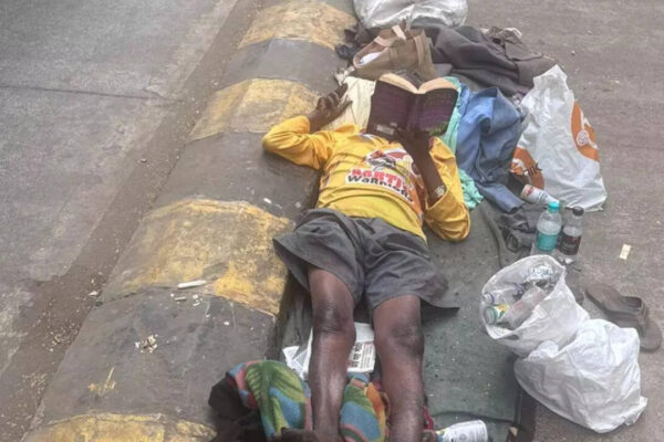A beggar was spotted reading Sidney Sheldon while lying on the footpath in a viral post: Who is he? |
