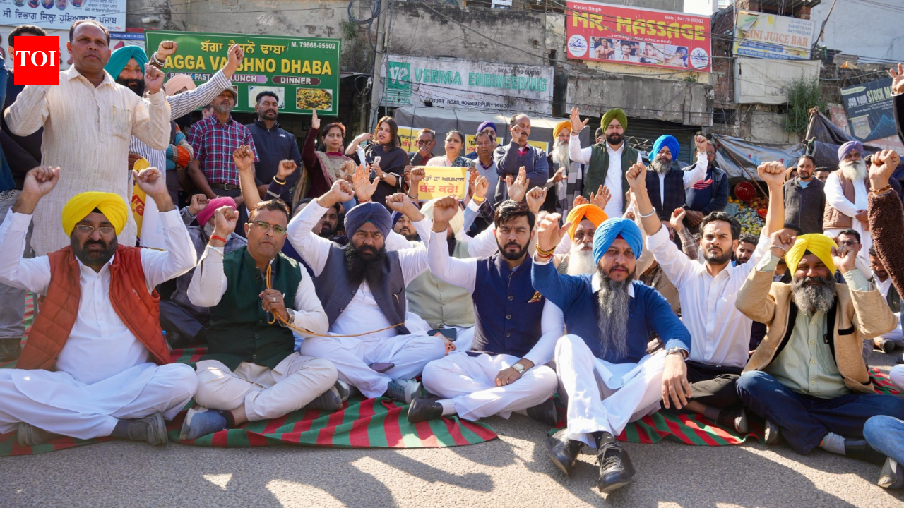 HOSHIARPUR: The Aam Aadmi Party (AAP) staged protests across Punjab on Friday outside the district Congress committee offices, responding to alleged remarks made by Leader of the Opposition Partap Singh Bajwa against state minister Harbhajan Singh.Led by party leaders, including ministers and MLAs, AAP members held sit-in demonstrations and raised slogans condemning Bajwa’s comments. In several locations, protests also took place outside the homes of Congress leaders.In Hoshiarpur, Deputy Speaker of the Punjab Assembly Jai Krishan Singh Rouri, along with some party MLAs, were among those present at the protest.The ruling party even arranged for a wedding band to play during the demonstrations as a symbolic protest against Bajwa’s alleged derogatory remarks.Addressing the gathering in Hoshiarpur, AAP leaders described Bajwa’s comments as “unfortunate and unacceptable,” demanding an apology from him. They stated that they would continue to oppose him on this issue during the upcoming Budget session of the Punjab Assembly.Bajwa had accused Minister Harbhajan Singh of corruption and stated that the Congress would hold him accountable once they form the government. “Jehra pehle band vajaanda reha, ehda band asin vajaavange (He who used to be a band player will be taken to task by us), Bajwa had said, referring to Singh.In response, Harbhajan Singh criticised Bajwa, asserting that mocking honest, hard-earned livelihoods was shameful. He noted that his father was a bandmaster who educated his children through hard work.Punjab State Scheduled Castes Commission chairman Jasvir Singh Garhi had taken suo motu notice of Bajwa’s remark. Bajwa’s counsel had said on Wednesday that the leader of the opposition (LoP) in the Punjab Assembly did not make any objectionable remarks against Harbhajan Singh.Bajwa’s denial came through his counsel Arvind Kumar Sachdeva, who appeared before the chairman of the Punjab State Scheduled Castes Commission in a case of his alleged objectionable remarks against Harbhajan Singh.Meanwhile, speaking to reporters during the protest in Hoshiarpur, Rouri said such language did not suit the LoP. “In a democratic system, it is not appropriate to make comments on someone’s background or profession. Such language has no place in Punjab,” he said.Rouri added that Bajwa’s remarks had hurt the sentiments of working-class individuals. He highlighted that Harbhajan Singh comes from a humble background and has achieved success through hard work, emphasising that disrespecting any profession goes against Punjab’s culture.”The band is traditionally associated with celebrations and the dignity of labour. Targeting someone for such work reflects a narrow mindset,” he said.Rouri further stated that political opposition should be based on issues and policies rather than personal or derogatory references.In Ludhiana, AAP protested outside the office of Punjab Congress chief Amrinder Singh Raja Warring, with Minister Hardeep Singh Mundian leading the demonstration. Mundian condemned the language used by Congress leaders.AAP demonstrators also staged protests in other areas, including Sri Muktsar Sahib, Moga, Bathinda, Amritsar, and Jalandhar, further highlighting their discontent.End of ArticleFollow Us On Social MediaVideos’Symbols Of British Empire’: PM Modi On North & South Block In 1st Address From Seva Teerth’Umar Bhar Yahi Bhool’: Yogi Adityanath Quotes Mirza Ghalib In UP Assembly To Target SP’s RecordBNP Demands Sheikh Hasina’s Extradition From India After Bangladesh Poll WinCongress Demands Union Minister Hardeep Puri Resignation Over Alleged Jeffrey Epstein Links RowPM Modi Speaks To BNP Chief Tarique Rahman, Congratulates On ‘Remarkable’ Bangladesh Poll Win6-Year-Old Dead, 5 Injured As Speeding Car Hits Pedestrians On Busy Lucknow Road; CCTV Shows HorrorKiren Rijiju Explains Why Modi Govt Paused Privilege Notice Against Rahul Gandhi After Dubey’s MoveTarique Rahman’s BNP Heads For Landslide In Bangladesh Election, Rivals Cry FoulPM Modi Unveils Seva Teerth, A New PMO Hub Marking Governance Shift In National Capital DelhiRafale To Be Built In India For The First Time Outside France After DAC Nod For 114 Fighter Jets123PhotostoriesTop 5 real estate hotspots in Noida to watch in 2026Seva Teerth opens doors: PM Modi launches new PMO complex in New Delhi – see picsAbs don’t equal healthy arteries: Doctor explains why appearance isn’t a health report card5 key features that make adventure bikes perfect for long-distance touring5 ways to remove pesticides from grapes and strawberries, tips for storage, and easy dishesFrom built-in air conditioners to radar ears: 5 animals with the weirdest ears and how they use themValentine’s Day 2026: 7 romantic red cocktails for Valentine’s Day celebrationFrom Titan Arum to Bulbophyllum Phalaenopsis: 7 worst smelling flowers of the worldDid you know Shahid Kapoor was rejected 100 times before his debut in ‘Ishq Vishk’? 6 lesser-known facts about ‘O Romeo’ actor5 hill forts of Rajasthan and why they are a traveller’s favourite123Hot PicksIT Stocks CrashGold Silver PricesBangladesh Election ResultsTelangana Municipal Elections ResultsIncome Tax CalculatorPublic holidays February 2026Bank Holidays februaryTop TrendingMarvel Rivals Season 6.5 Release dateErika KirkBad BunnyCatherine Polli Net WorthSeahawks Super Bowl paradeKayla NicoleAnthony JoshuaChloe KimCardi BMax Muncy